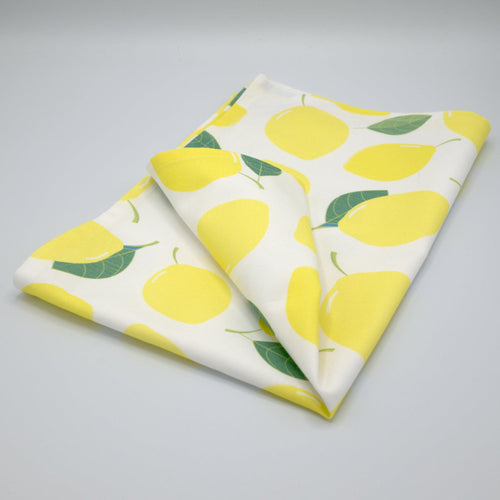 Amalfi lemon folded kitchen towel with lemon pattern on a gray background from Hem And Tassel 