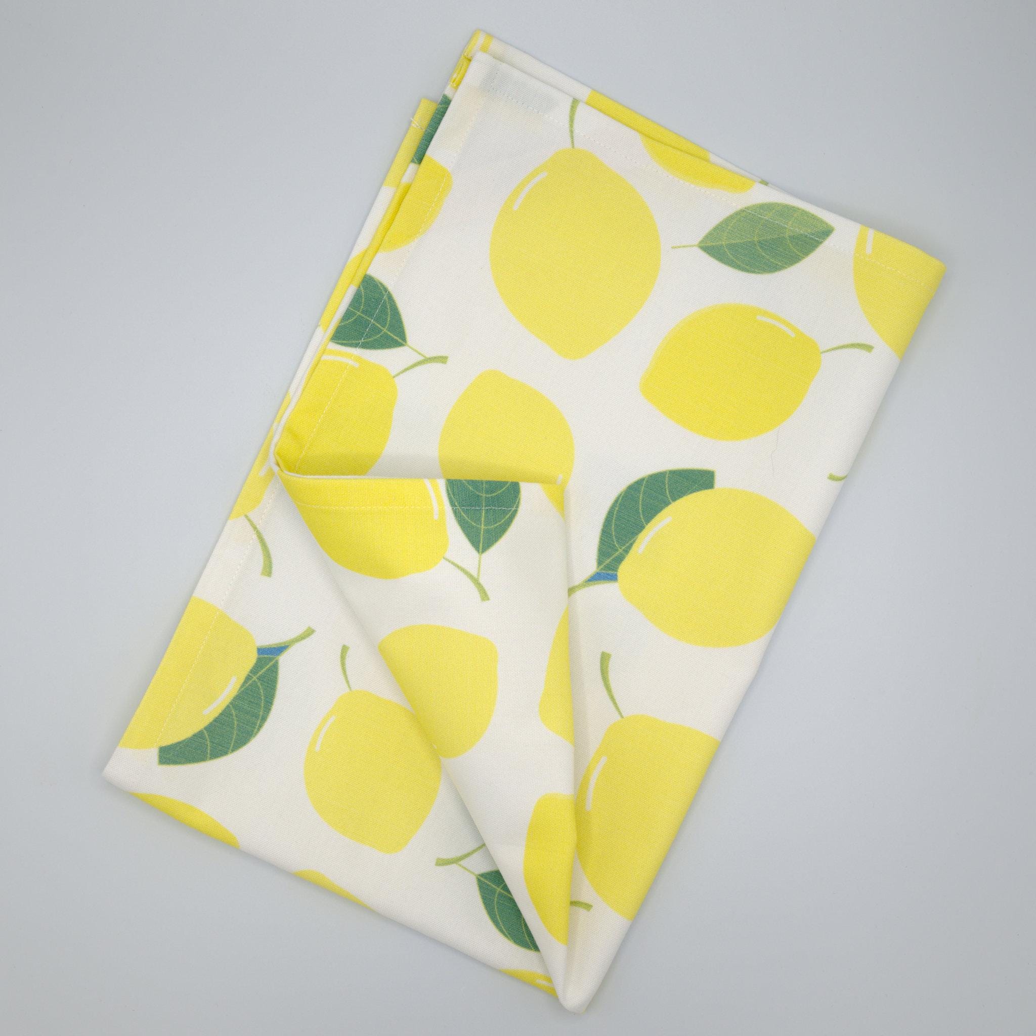 Folded Amalfi lemon towel with lemon pattern on a gray background from Hem And Tassel 