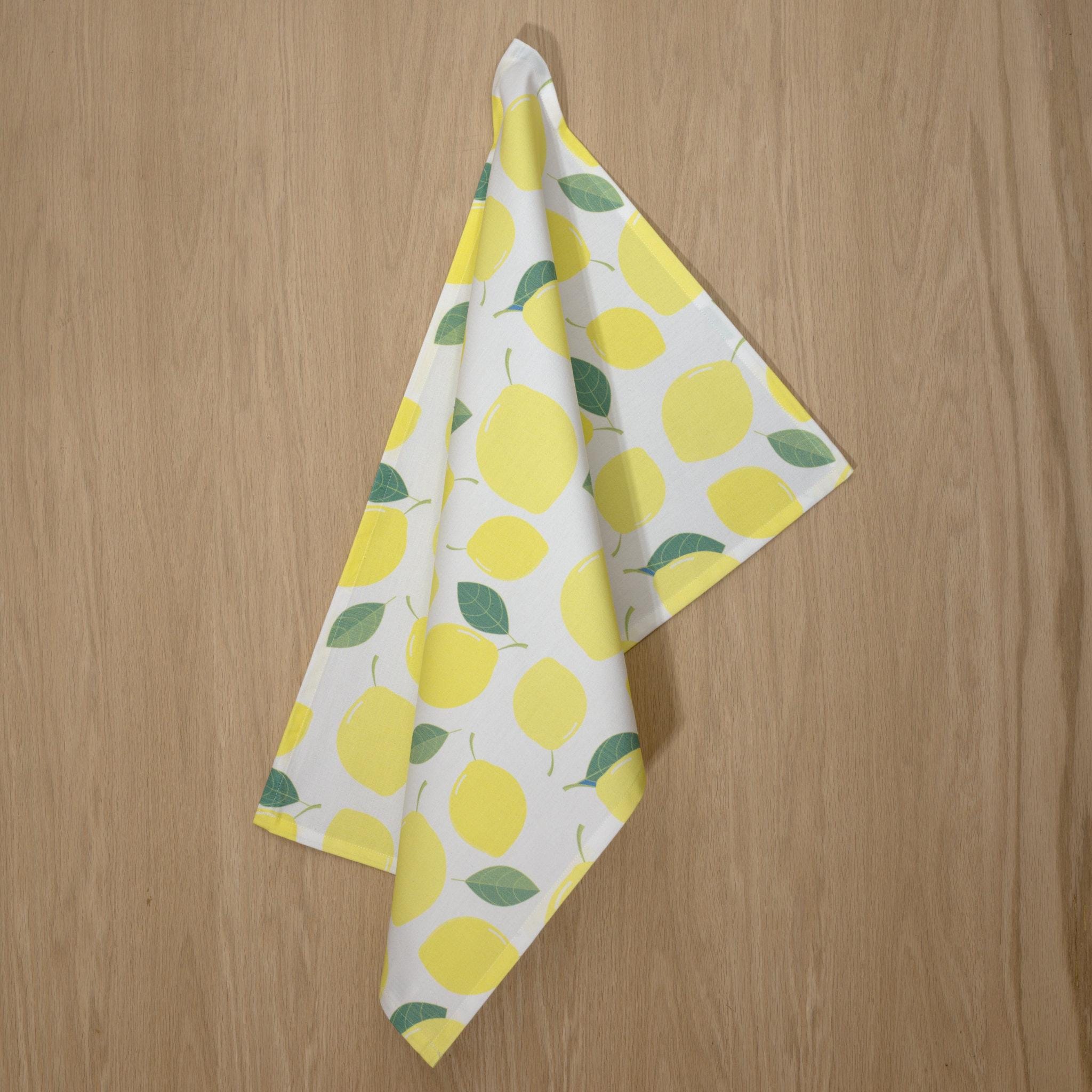 rich cotton percale kitchen towel of Amalfi Lemon design hanging against wooden backdrop - from Hem And Tassel
