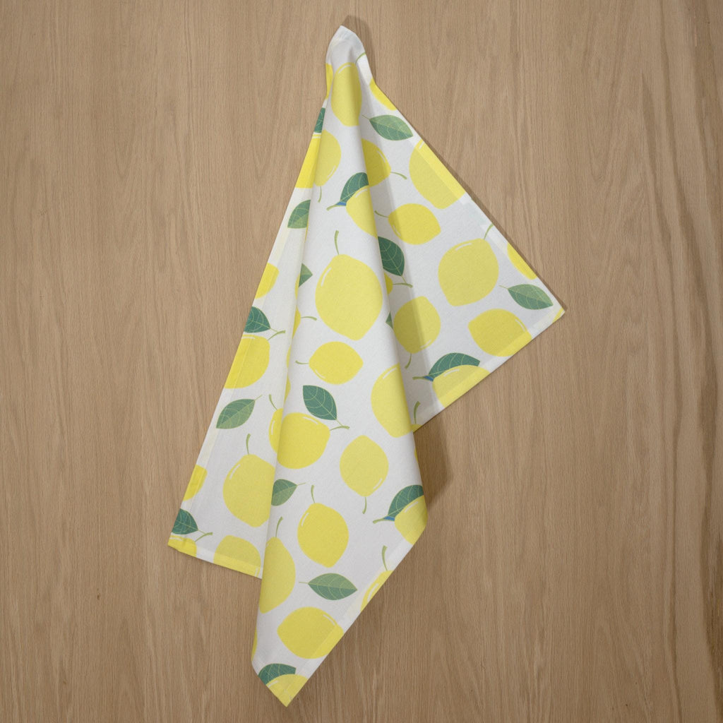 Towel with lemon pattern on a wooden surface from Hem And Tassel 