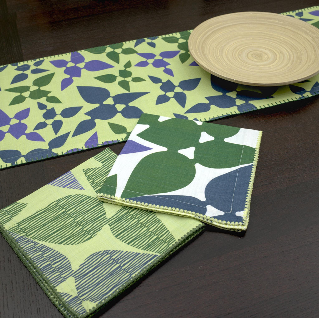 Green and blue patterned desert haze table runner on a dark surface from hem and tassel