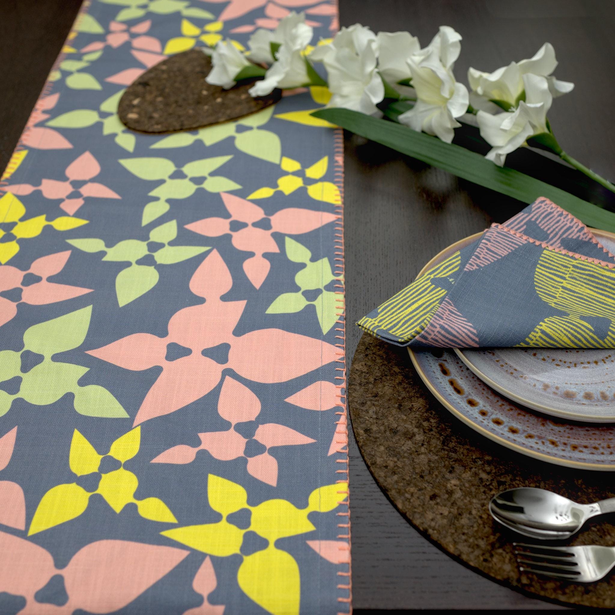Colorful patterned Celebration dinner napkins and table runner on a table setting from hem and tassel