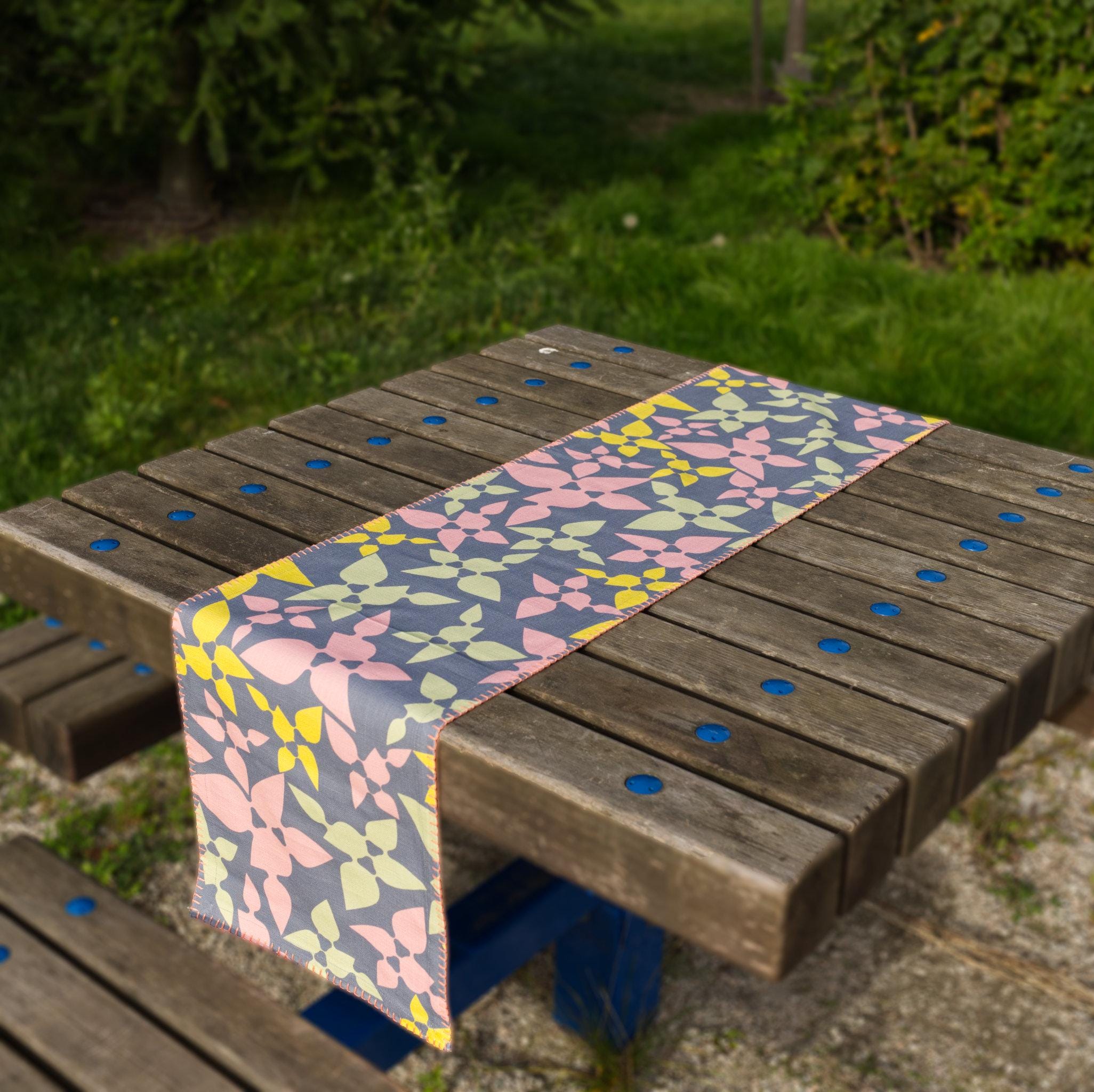 Celebration table runner park on a wooden table outdoors from hem and tassel