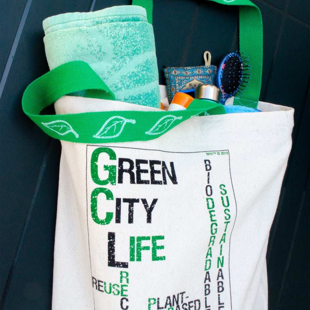 Green City Life tote bag with green strap and items on a dark surface from Hem And Tassel 