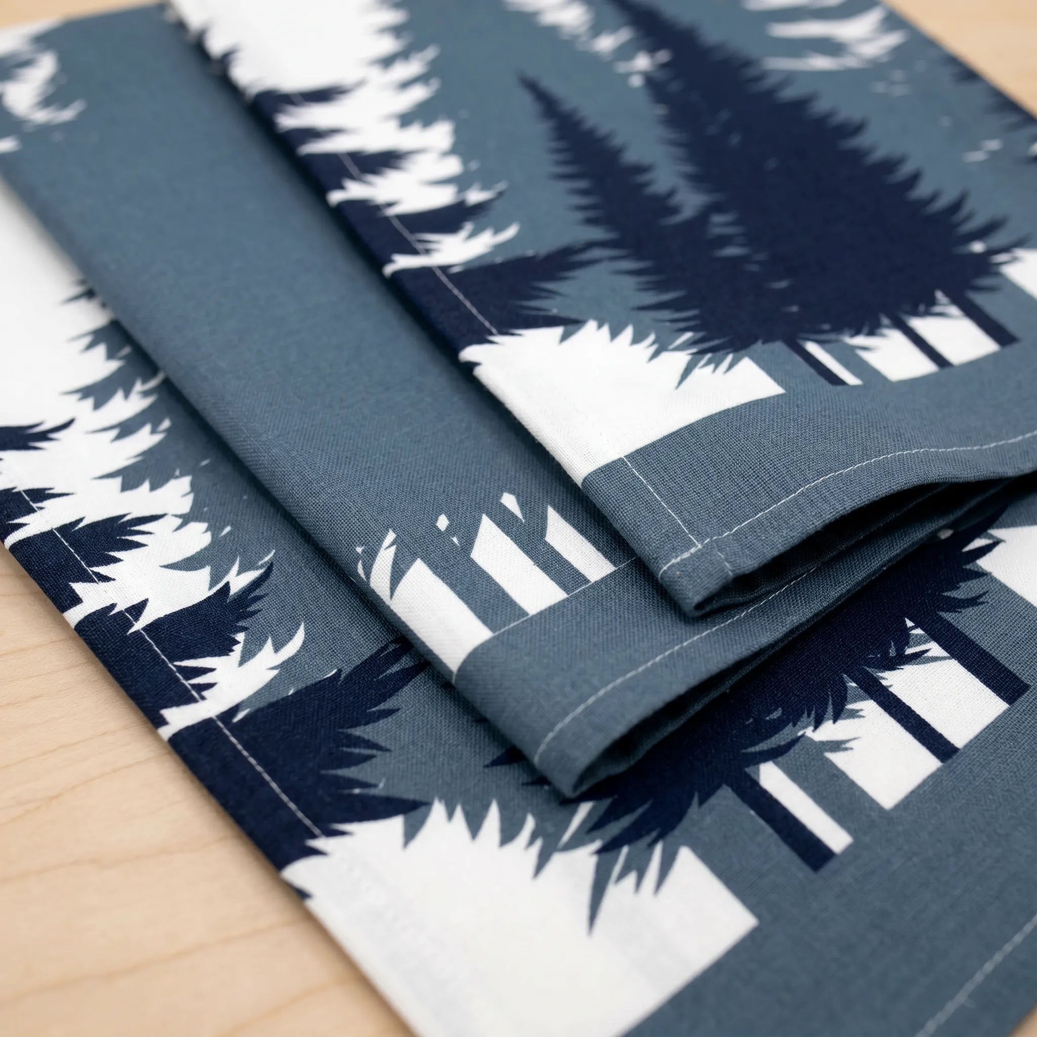 Folded cotton kitchen towel set of 3 with tree pattern on a wooden surface from Hem And Tassel