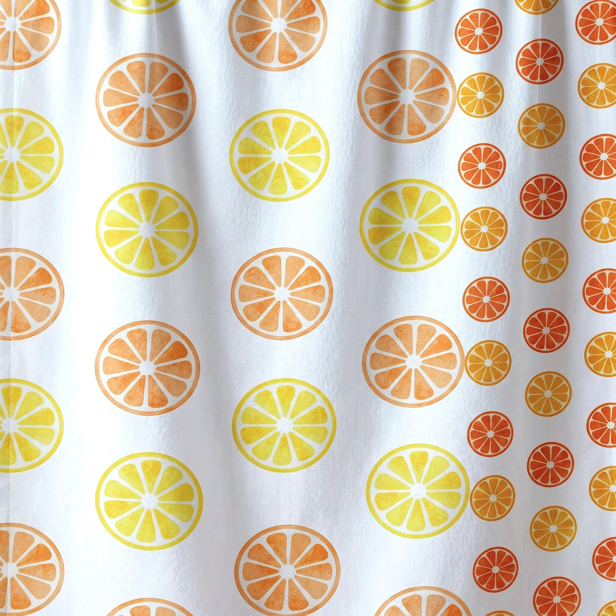 White cotton kitchen towel close up with a repeating orange slice pattern in light and dark orange and yellow from Hem And Tassel