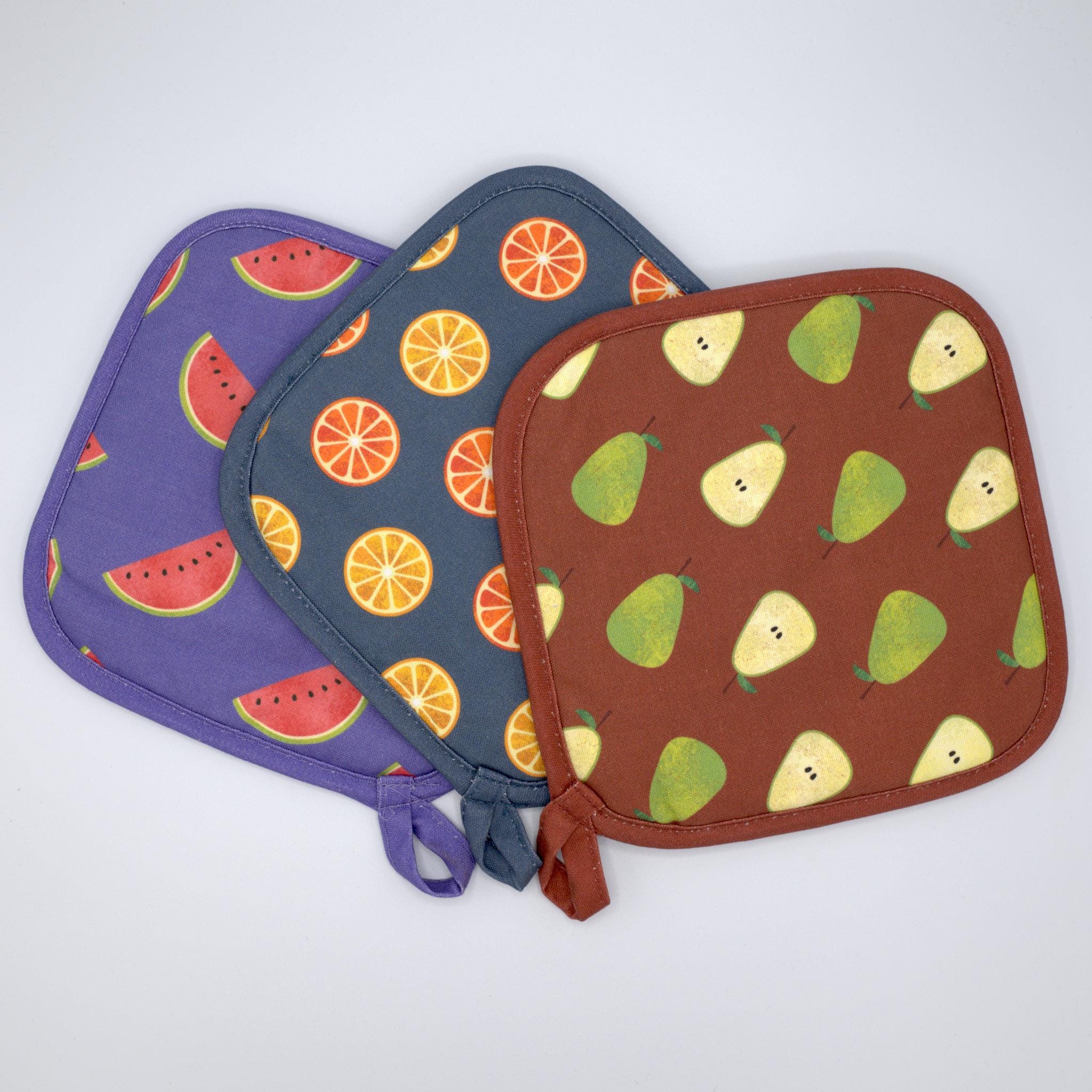 Three pot holders with faded fruit patterns on a white background from Hem And Tassel 