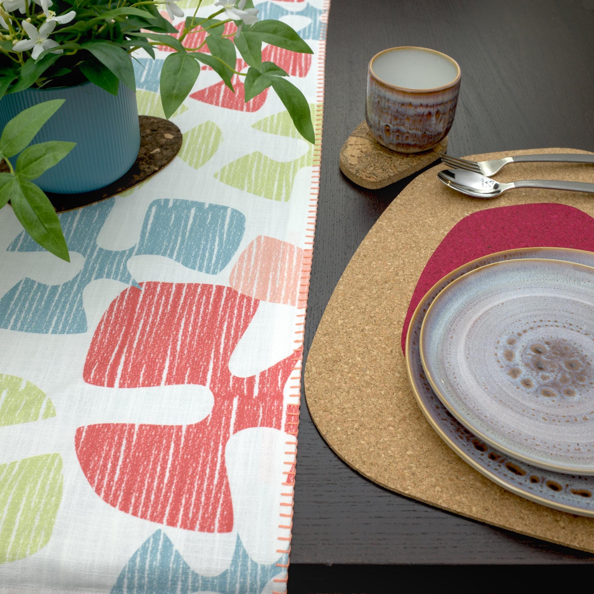 close up textured slub cotton table runner with decorative hems, of flutter design 'shine' on dining table with place setting and cork placemat - from Hem And Tassel