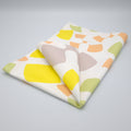 Folded Flock and Flutter design tea towel with colorful abstract pattern on a gray background from Hem And Tassel 