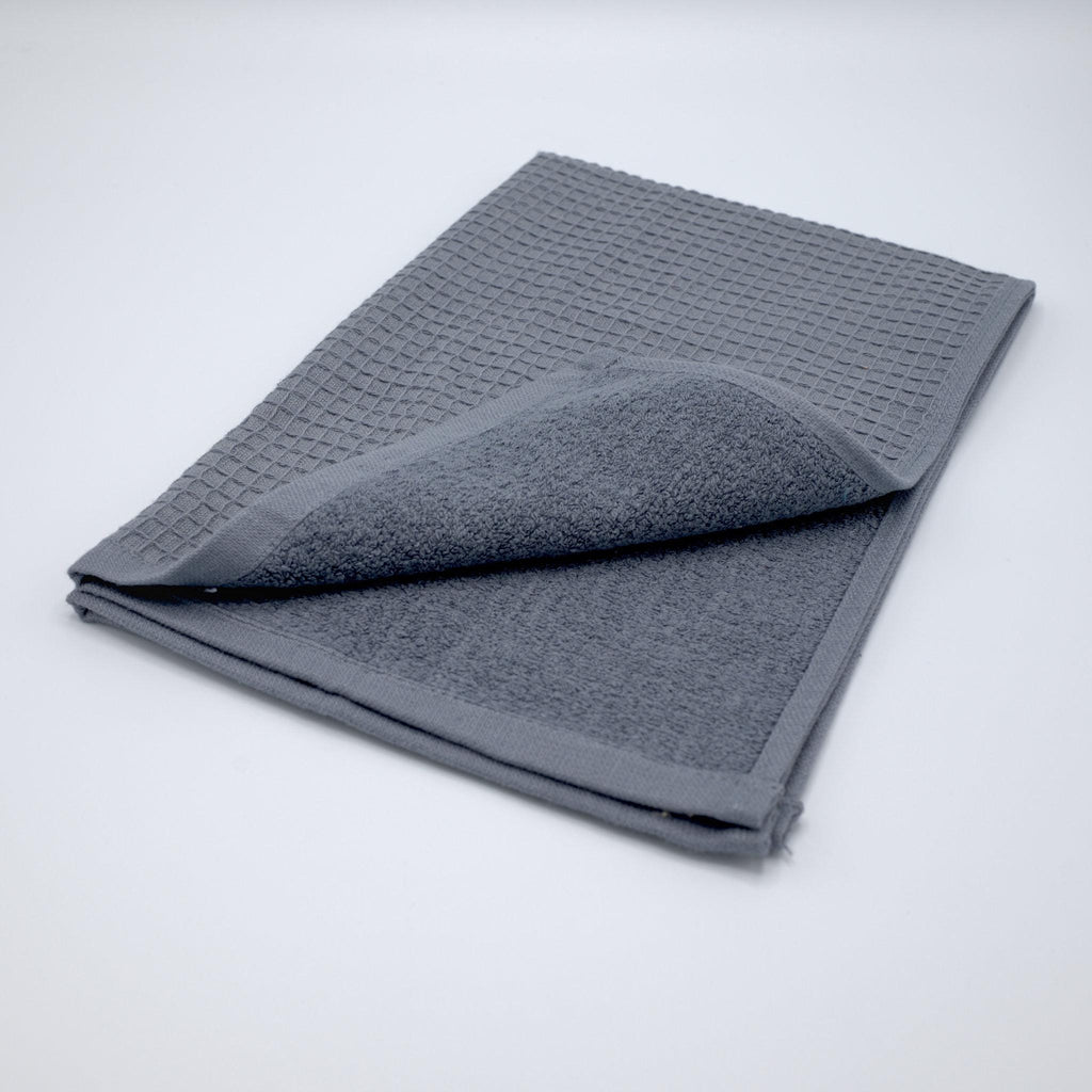 Folded gray textured Jekyll and Hyde  towel on a light gray background, with both textures