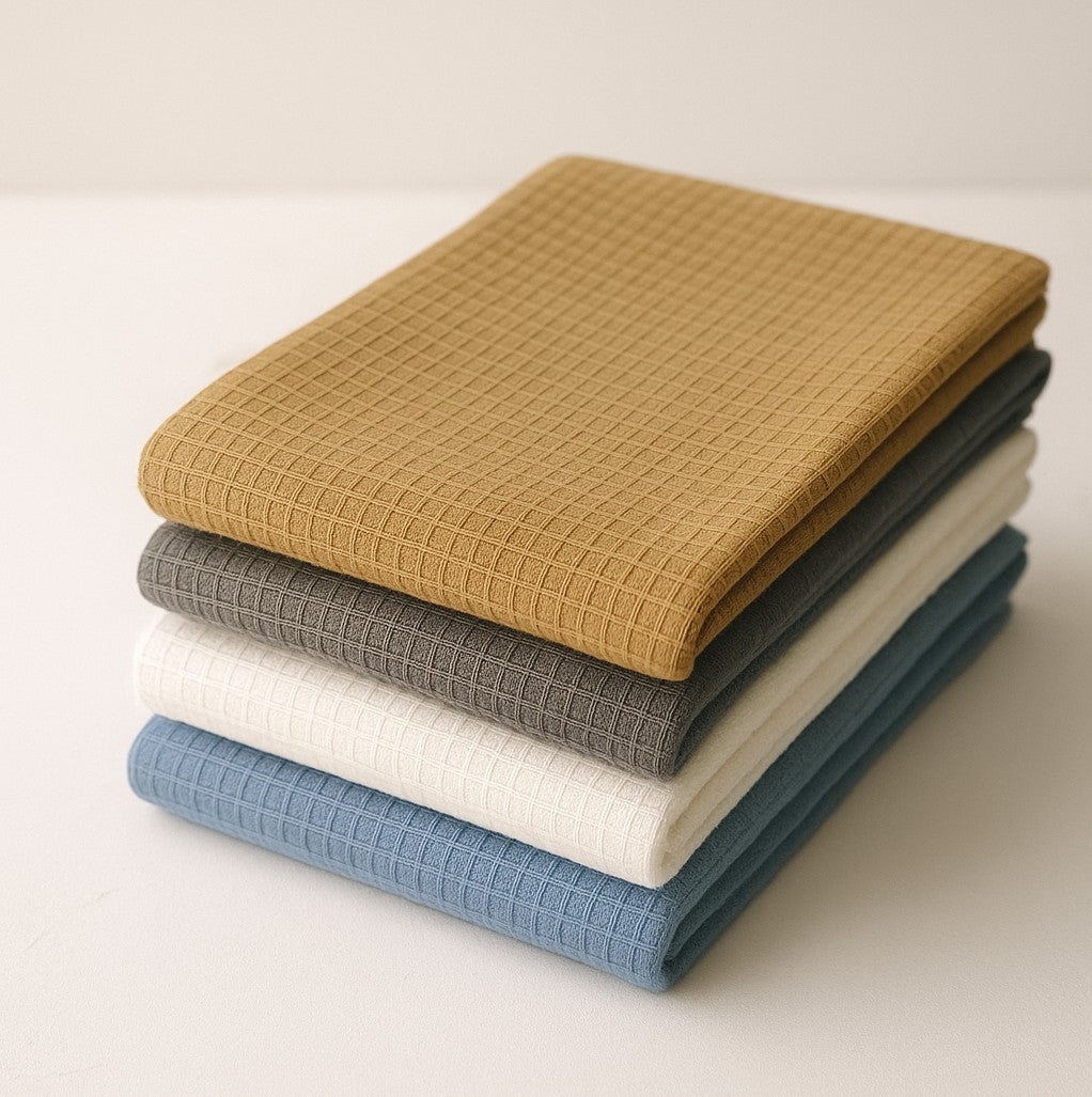 Stack of Jekyll And Hyde reversible towels in various colors on a light background from Hem And Tassel