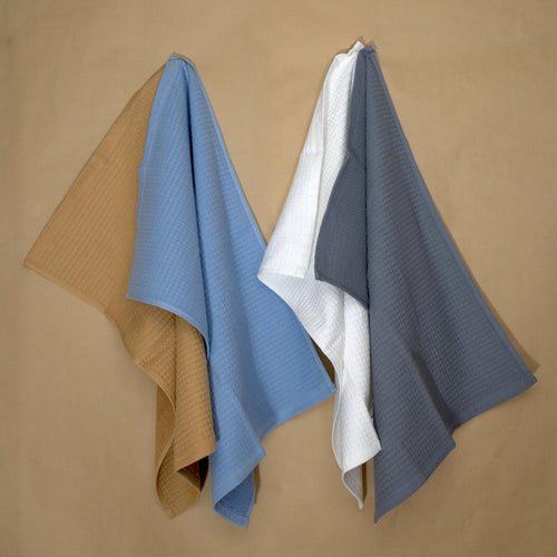 Jekyll and Hyde reversible kitchen or bath towels in four colors hanging on beige background- from Hem And Tassel