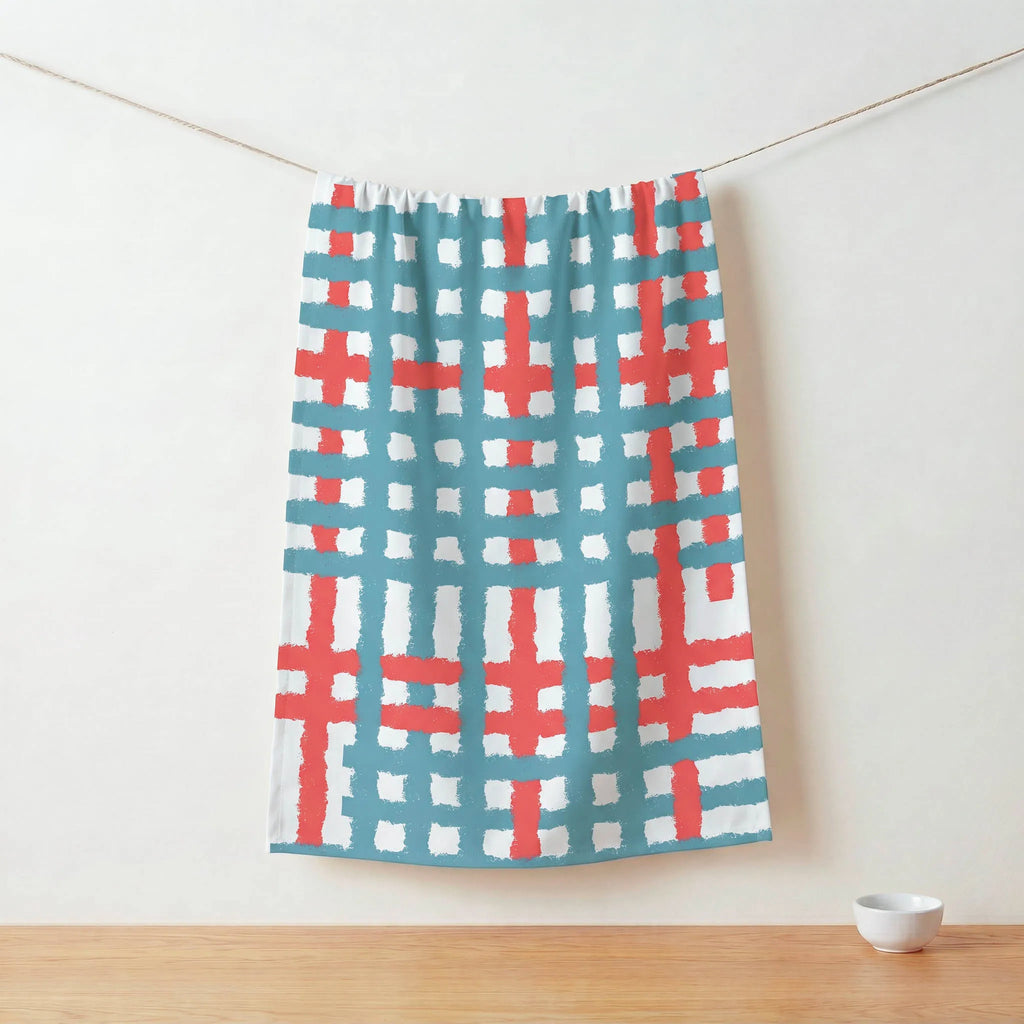 Colorful patterned cotton kitchen towel  hanging on a line against a white wall from Hem And Tassel 
