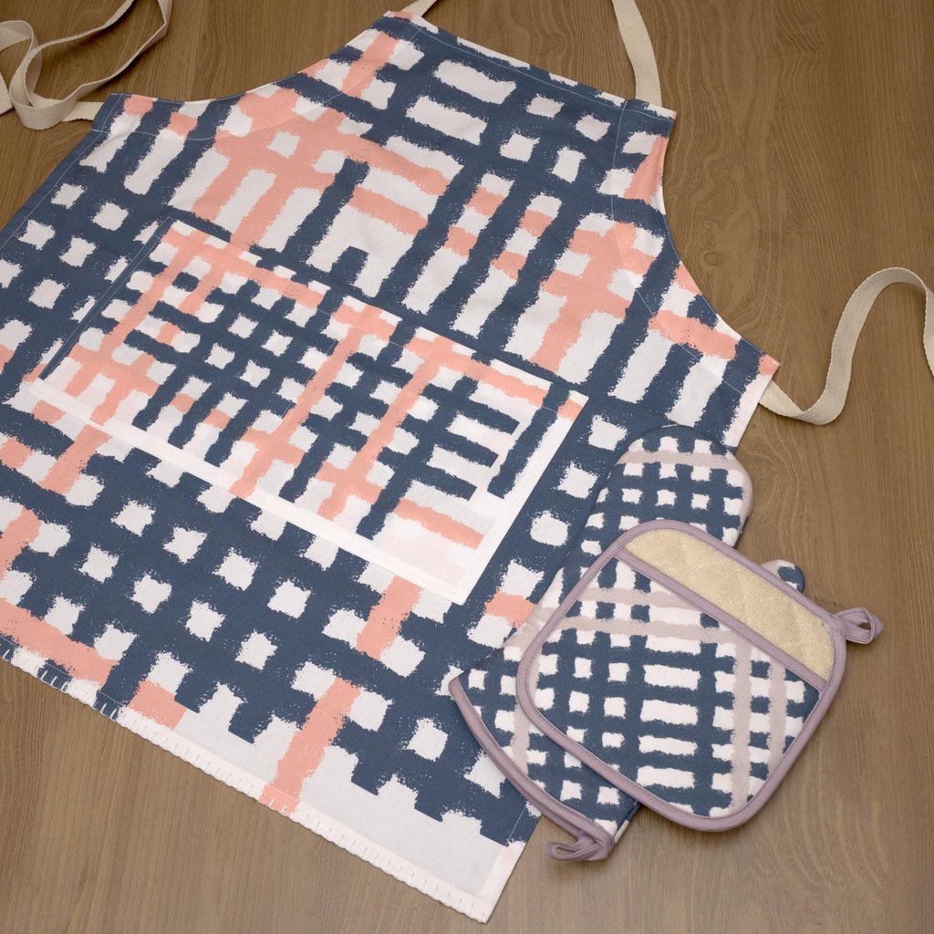 Jute Impossible checked pattern apron  and pot holder on a wooden surface from Hem And Tassel 