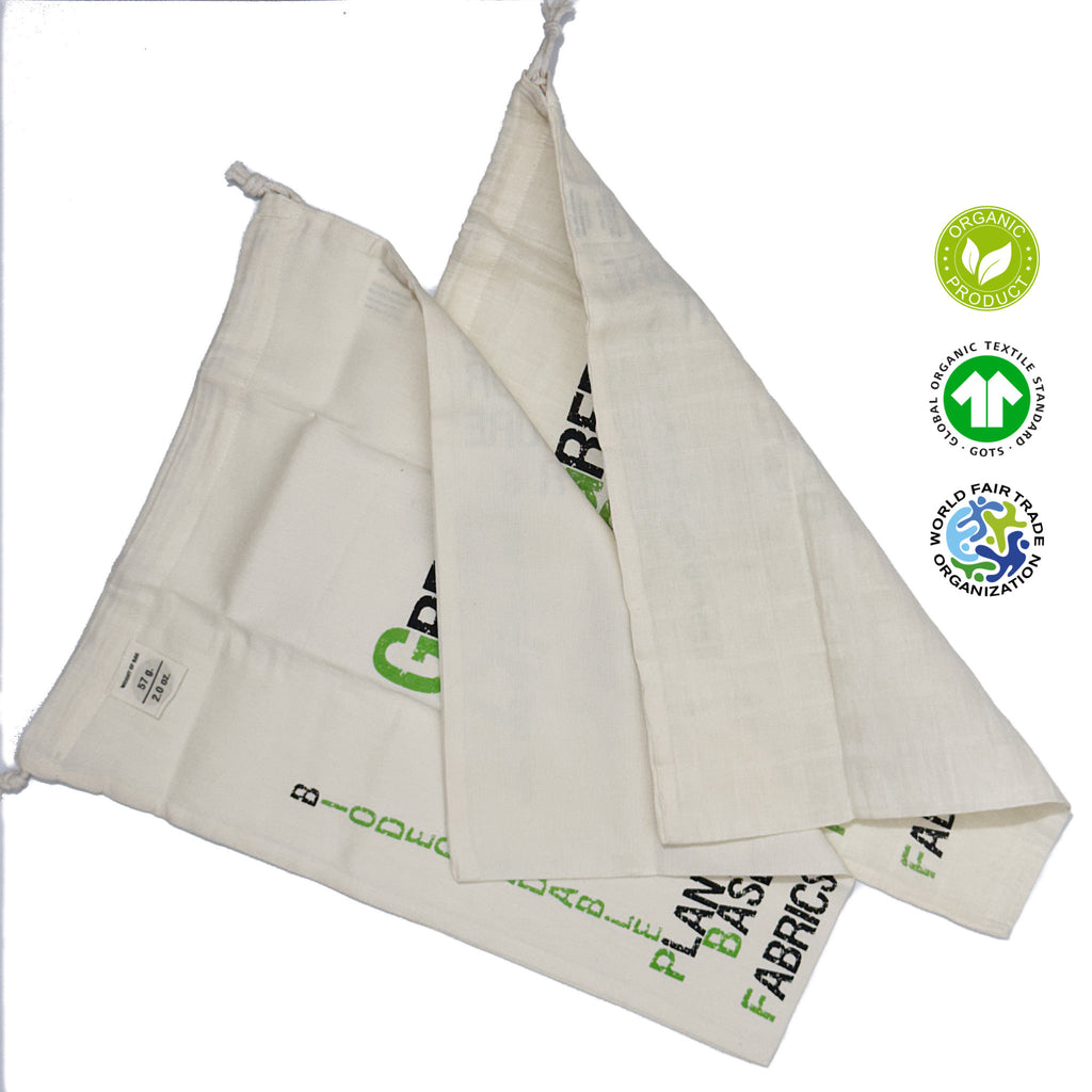 Two white fabric produce bags with green text and logos on a white background from Hem And Tassel 