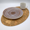 Ceramic plate and mug on a Large oval bark peel cork placemat with a white background