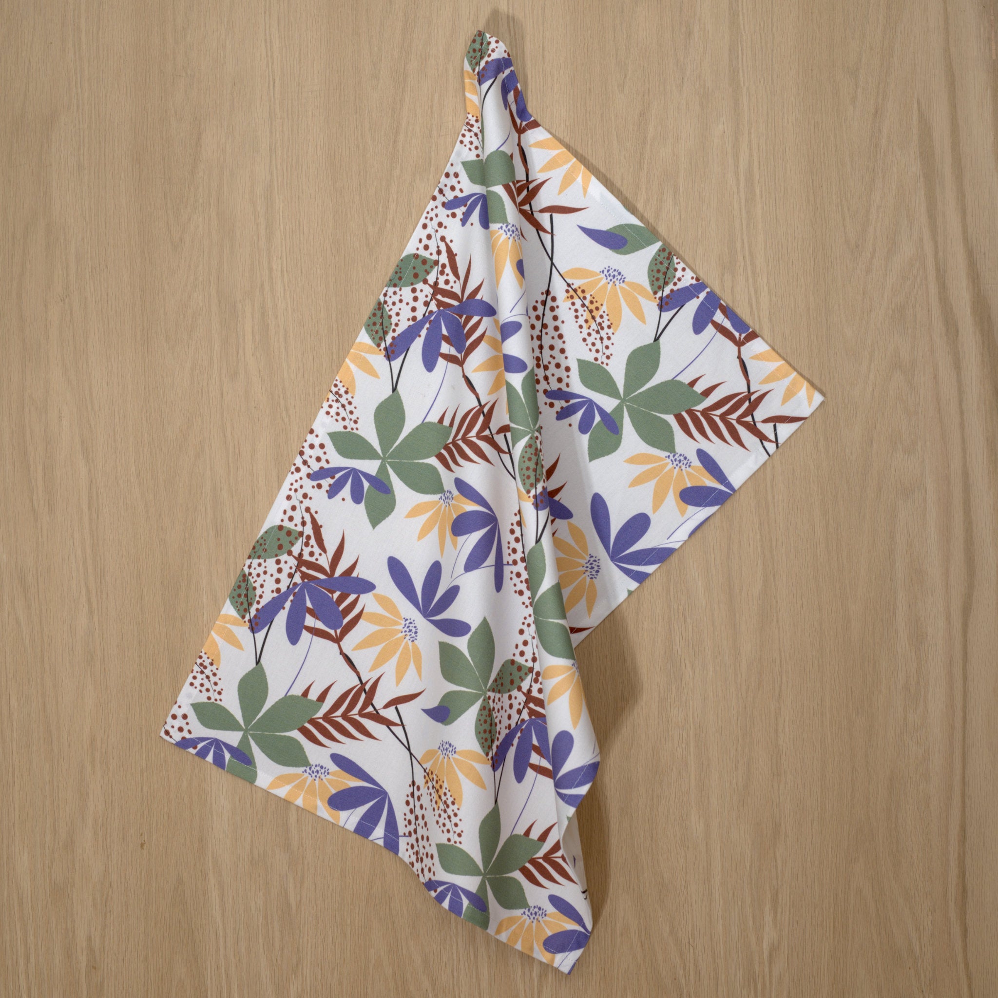 Fall colors in pollen up design tea towels hanging on a wooden backdrop