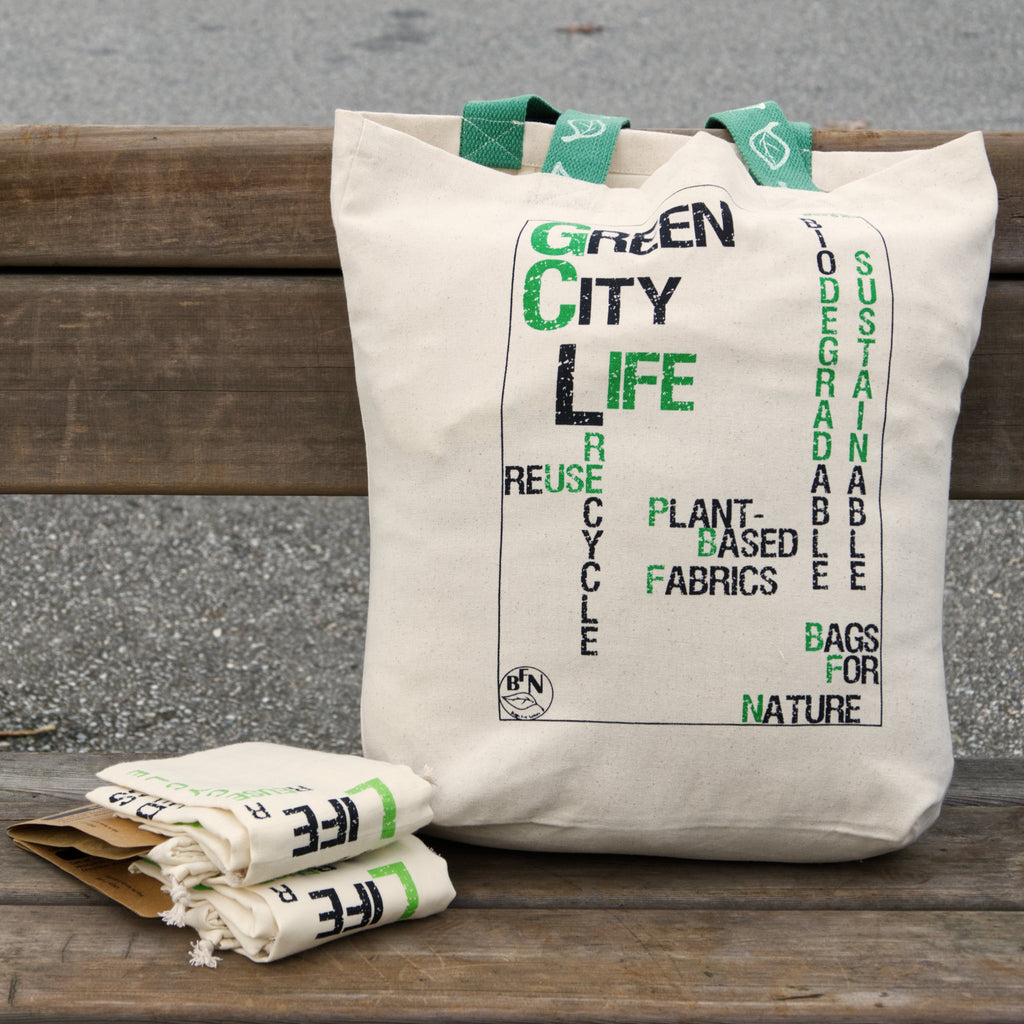 Tote bag with 'Green City Life' text on a wooden bench from Hem And Tassel 