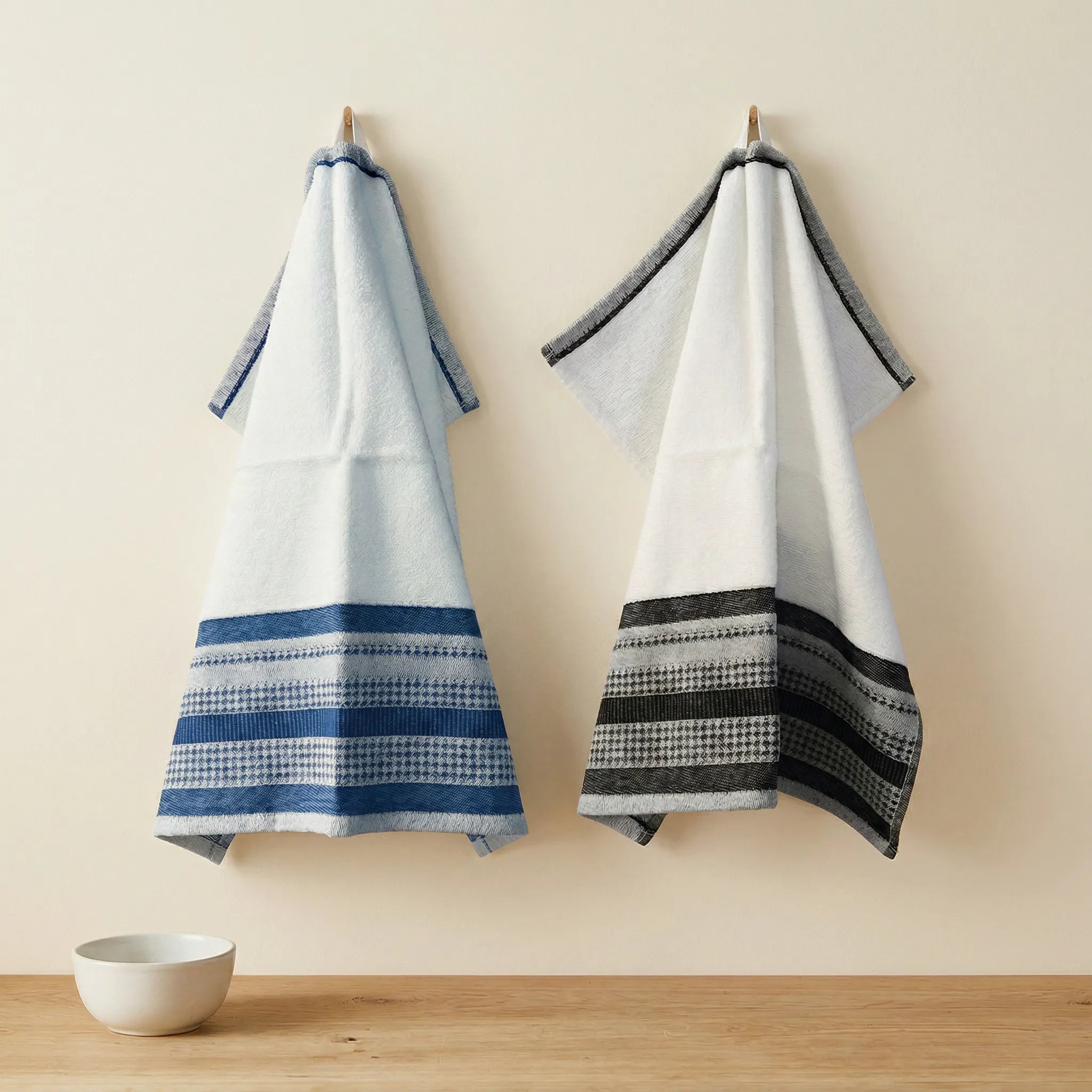 luxurious deep pile Terry towels with houndstooth border one in blue and one in black, hanging against a cream colored backdrop from Hem And Tassel 