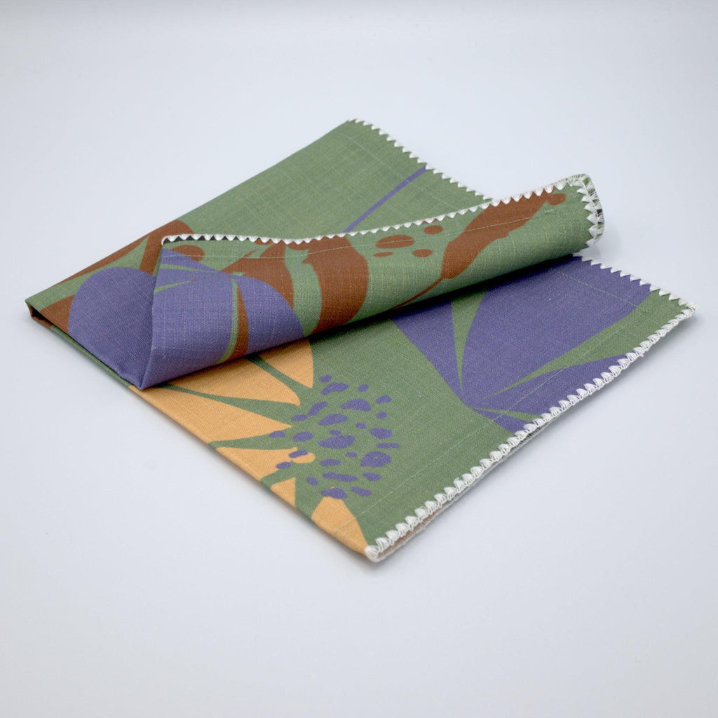 Folded with corner rolled back turf and buff colored 'Pollen Up' design pure cotton dinner napkin by Hem And Tassel