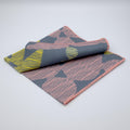 celebration slub cotton dinner napkin of blush and yellow print on dark grey,against a light grey background - from Hem And Tassel