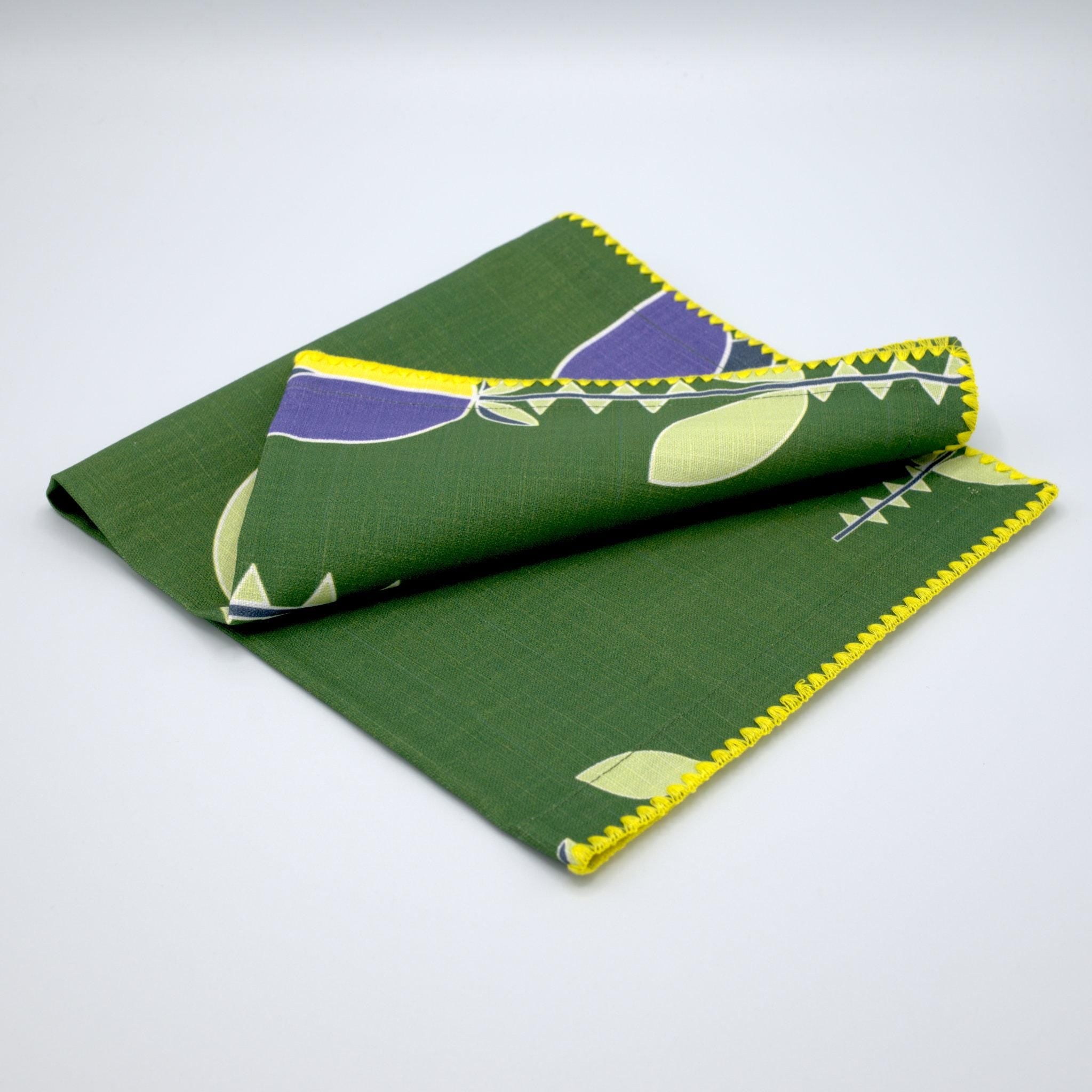 slub-cotton dinner napkin of Lip Tulip design in green, against light grey backdrop- from Hem And Tassel