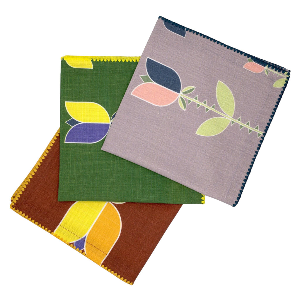slub-cotton dinner napkins of Lip Tulip design in four colors, fanned out against light grey backdrop- from Hem And Tassel