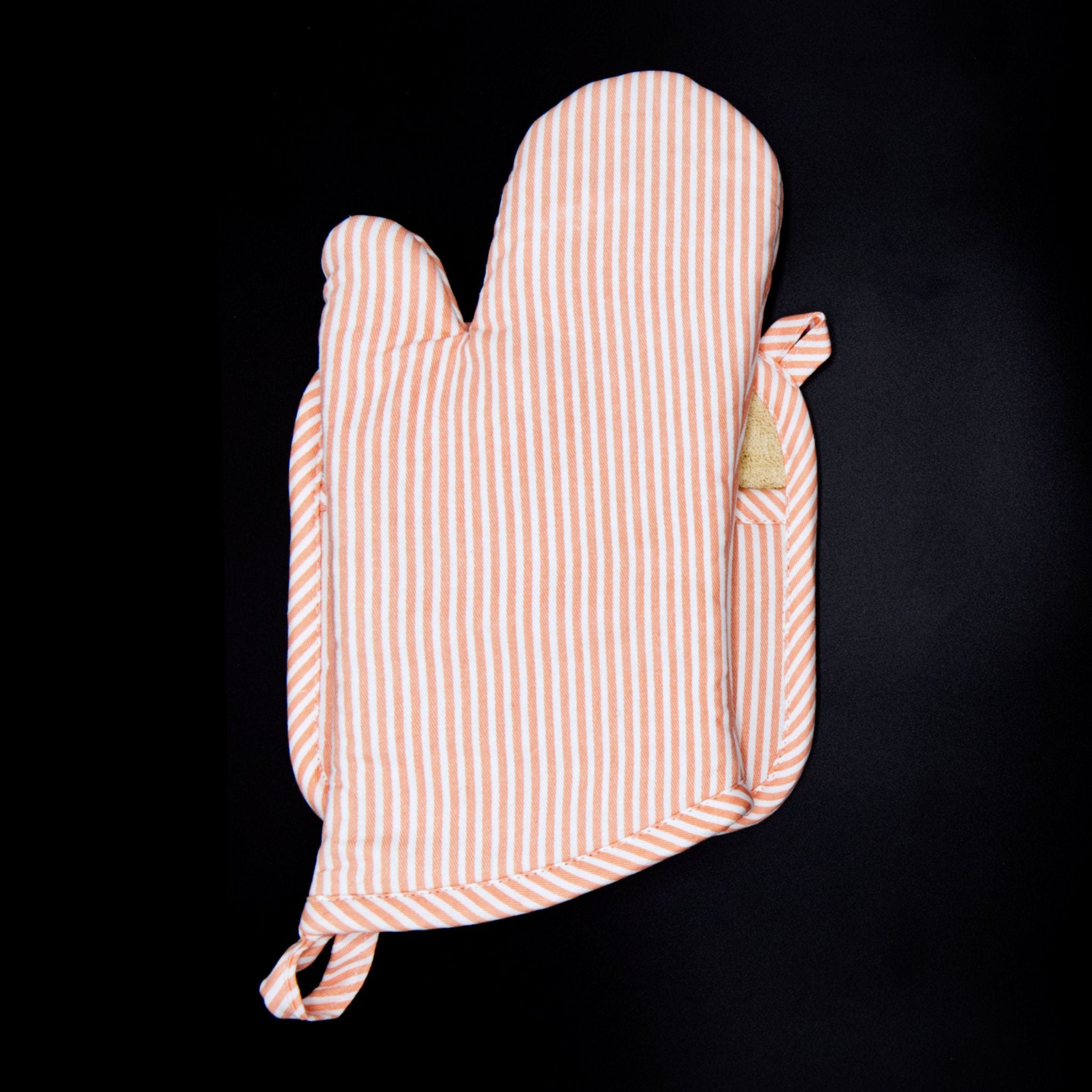 banker strip blush pot holder an oven mitt from hem and tassel on a black background