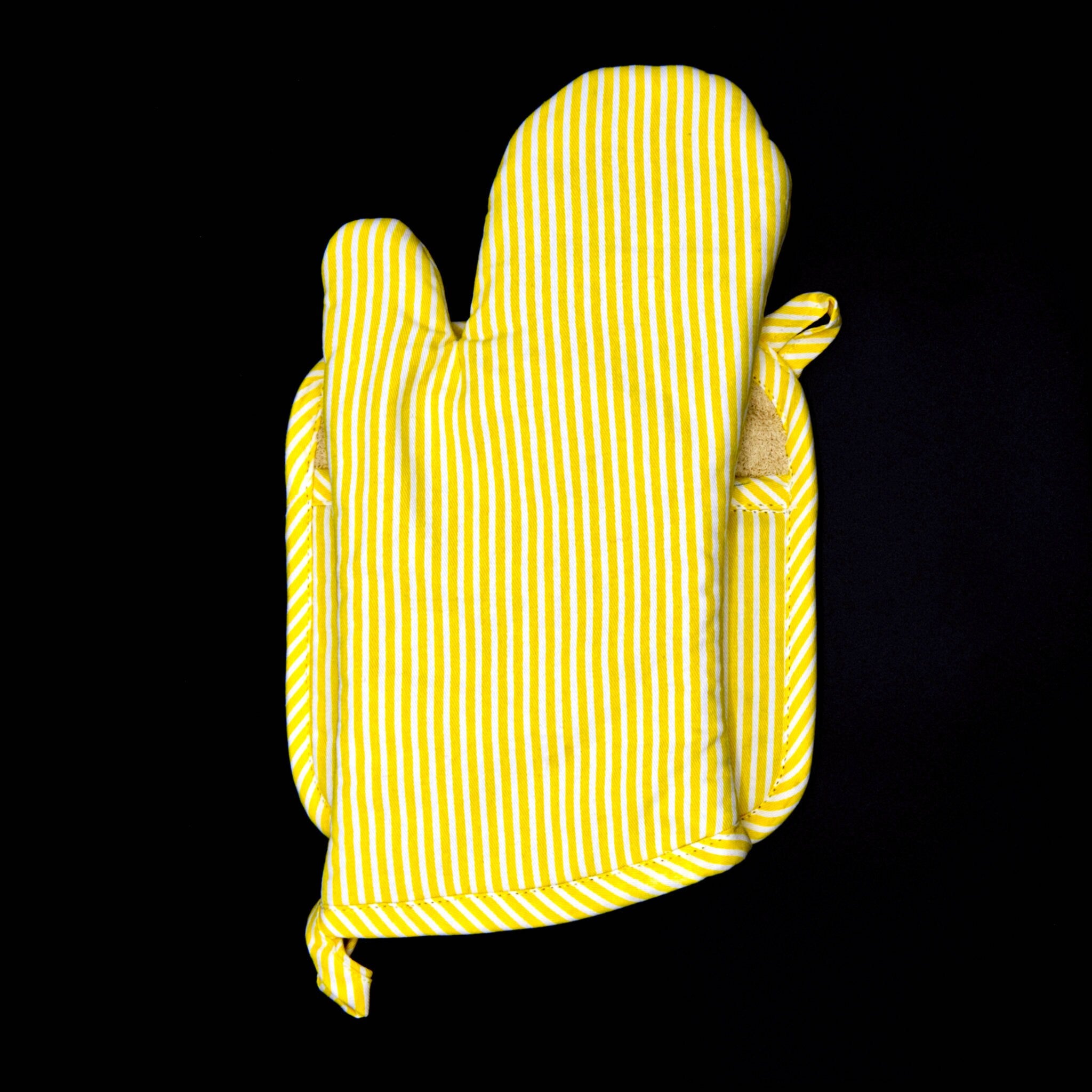banker strip buttercup pot holder and oven mitt on a black background from hem and tassel