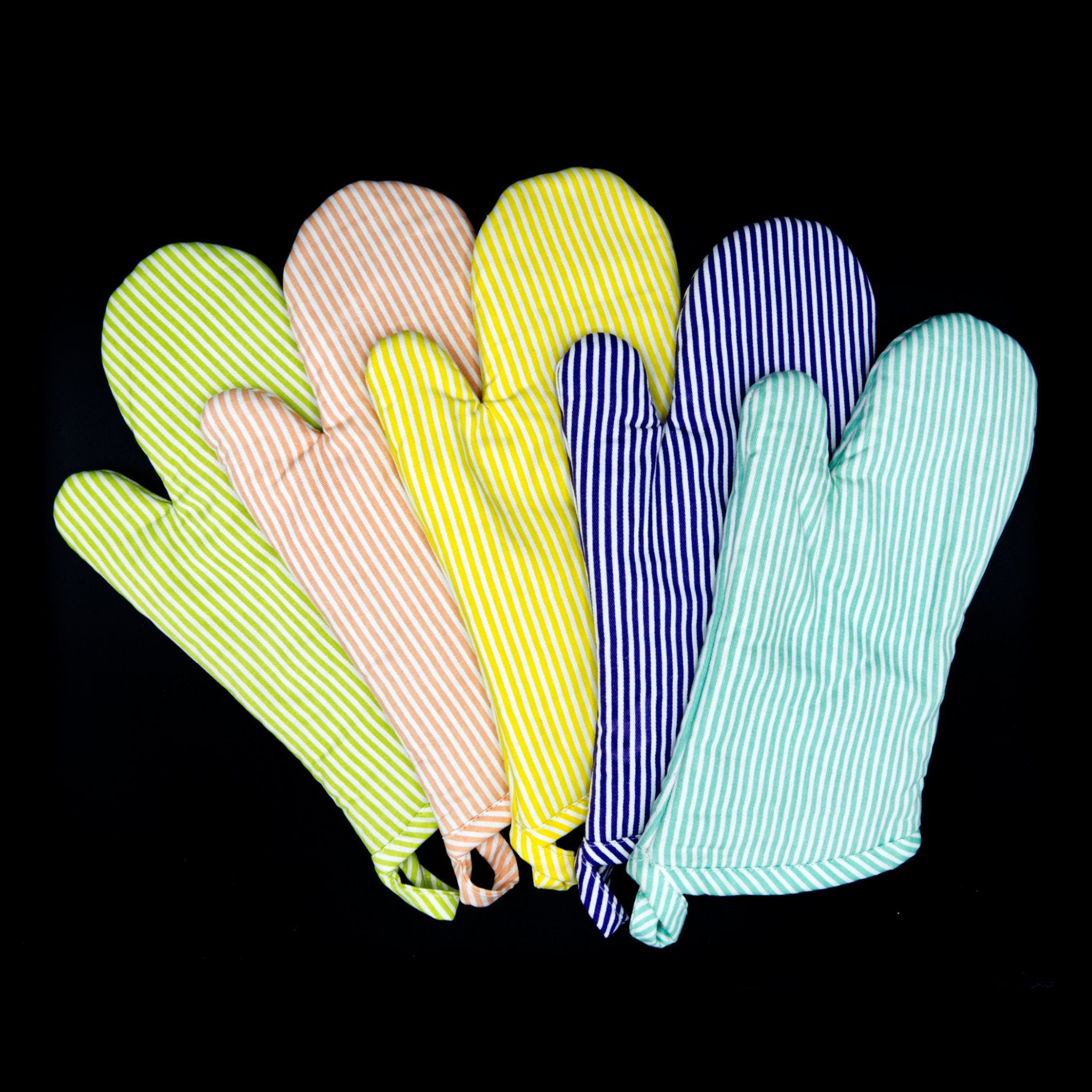 Set of colorful banker stripes oven mitts fanned out on a black background from hem and tassel