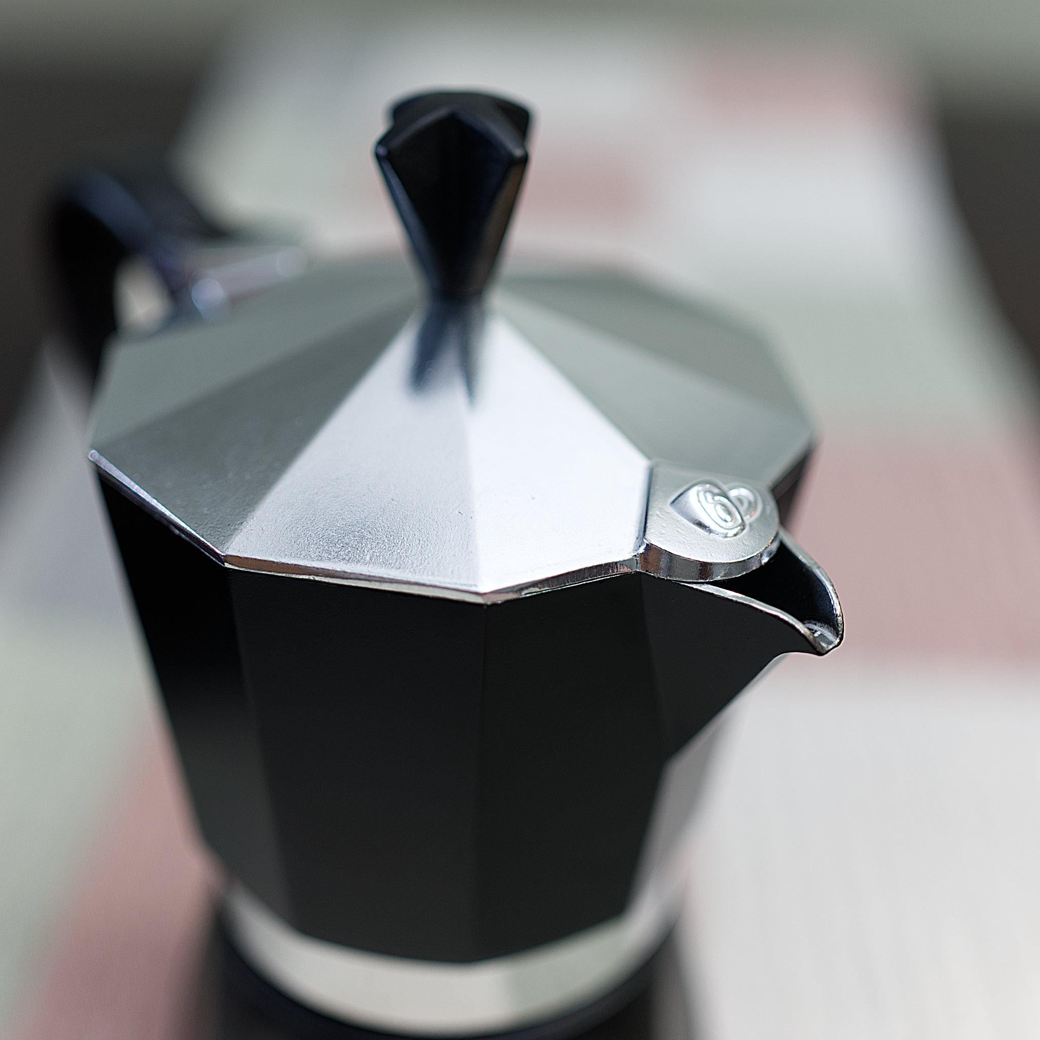 close up of top of made in italy black dolce moka pot from Hem And Tassel against a blurred background