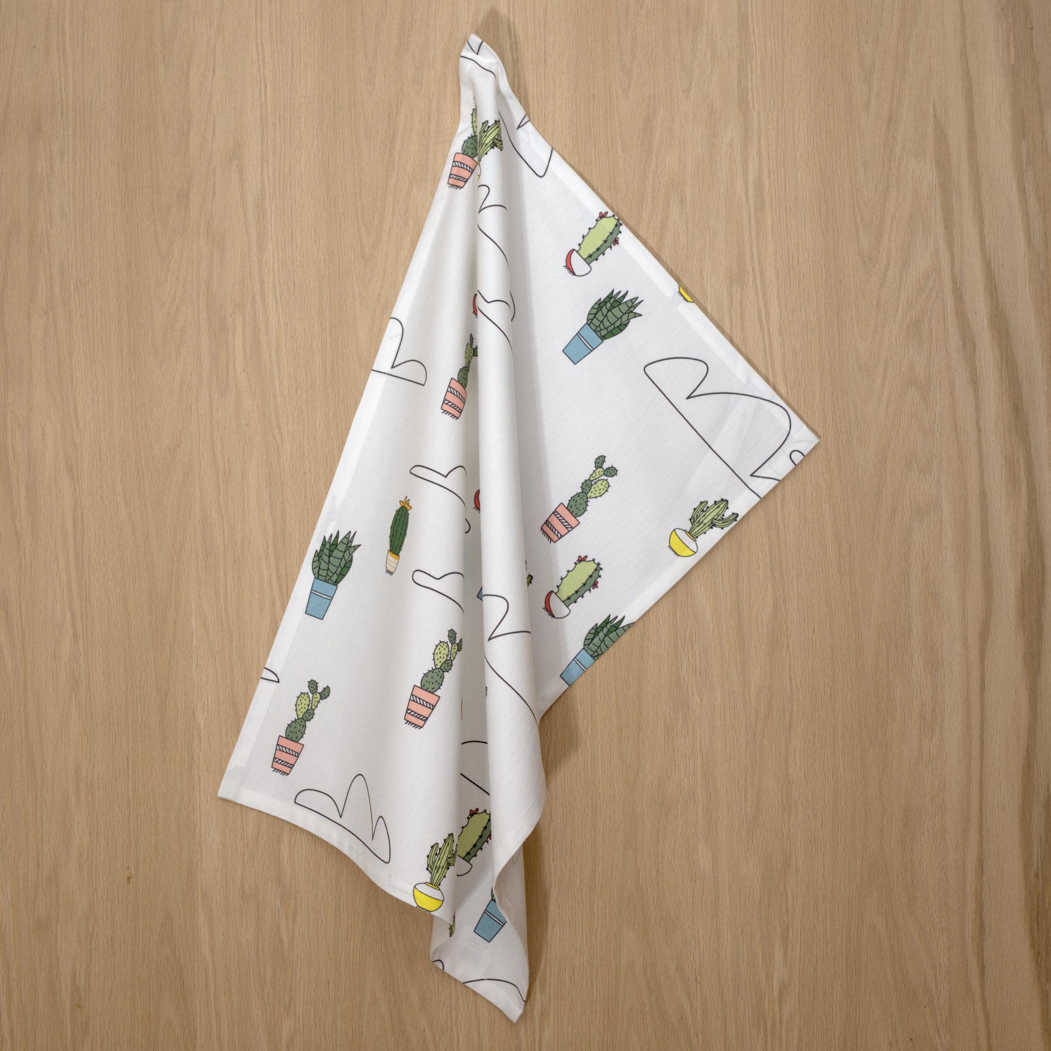 rich cotton percale kitchen towel of cloud and cactus design hanging against a wooden backdrop - from Hem And Tassel