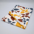 rich cotton percale kitchen towel of 'celebration' design in clay, on light grey backdrop - from Hem And Tassel