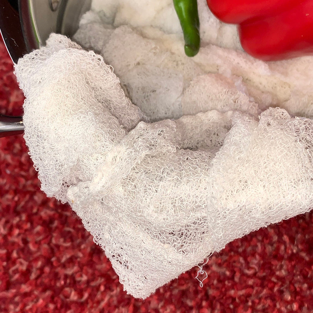 Certified Organic Cheesecloth with peppers on a red textured background from Hem And Tassel 