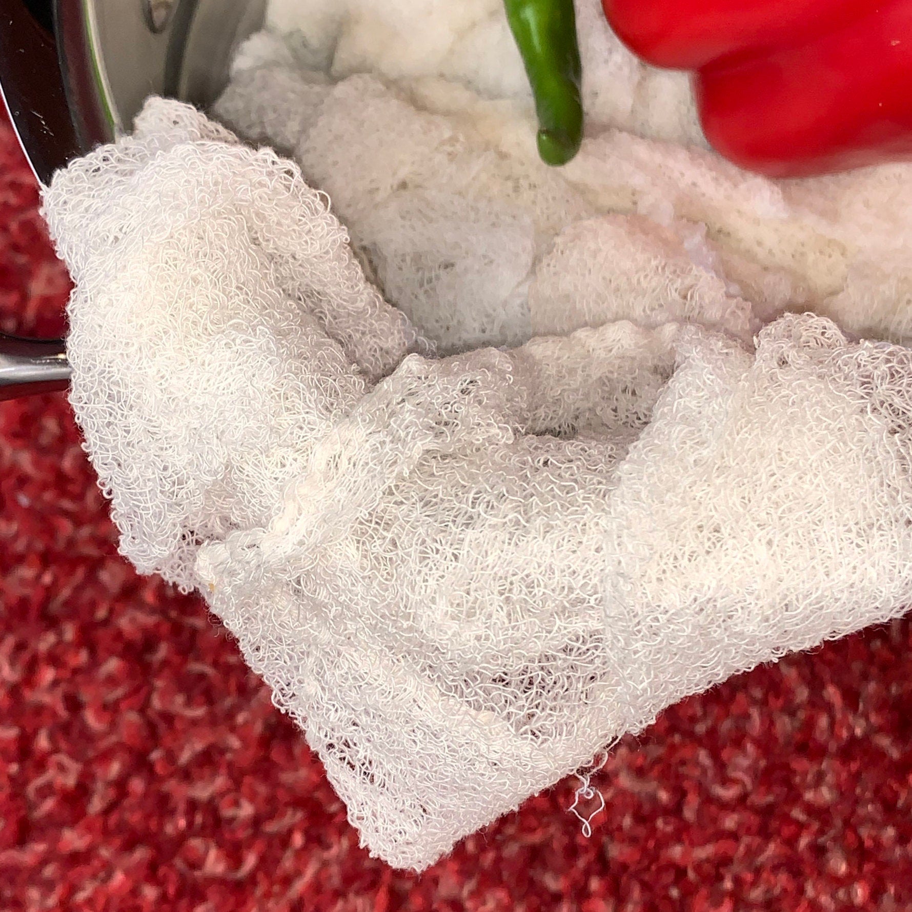 Certified Organic Cheesecloth with peppers on a red textured background from Hem And Tassel 