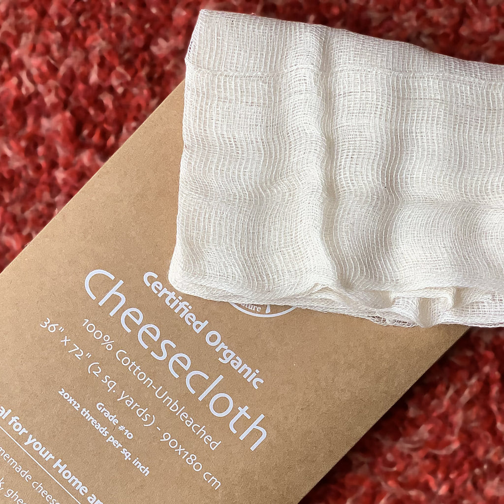 Certified Organic Cheesecloth package with white cheesecloth on a red textured background from Hem And Tassel 
