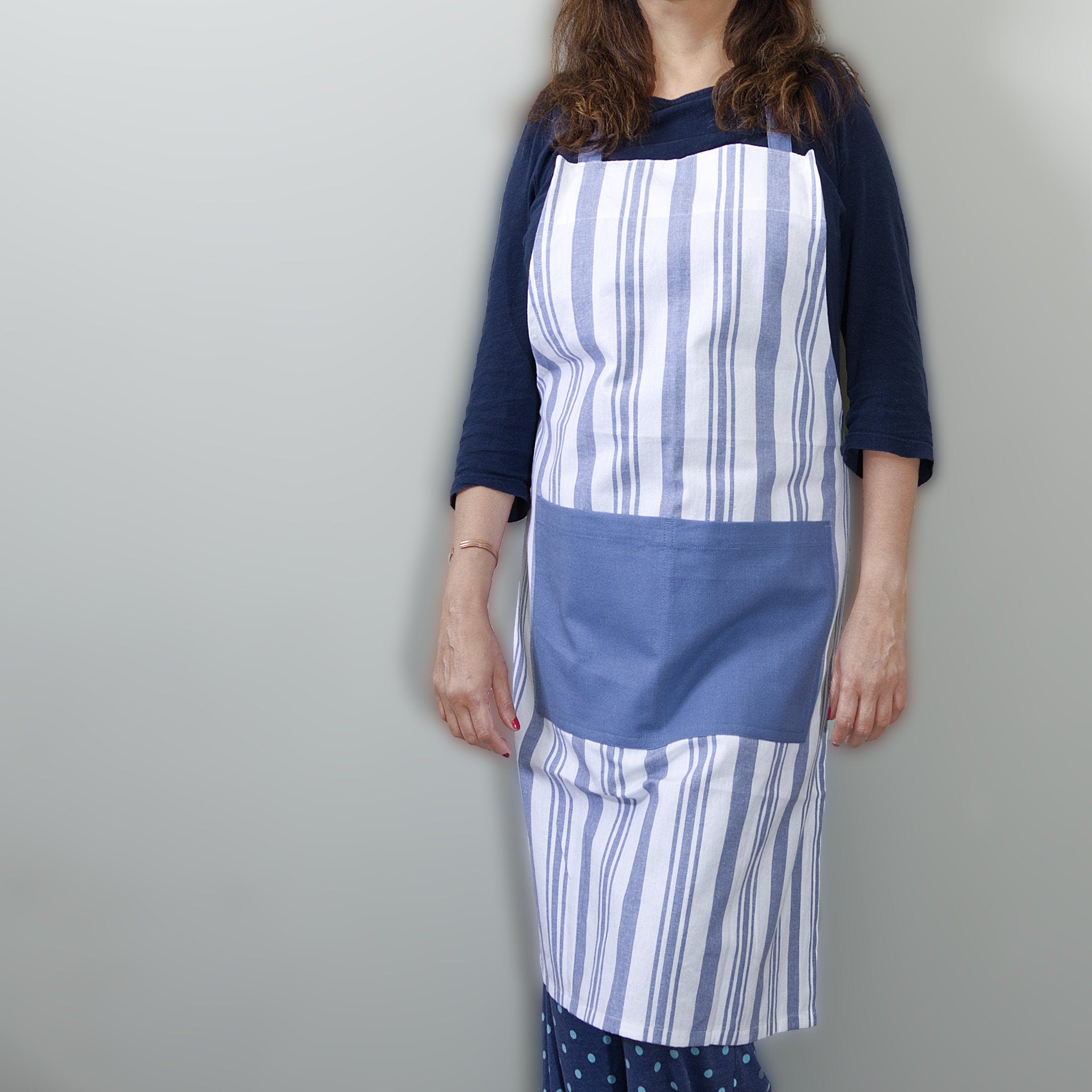 decade classic striped cotton Apon in blue stripes on white from Hem And Tassel on person  against a grey background