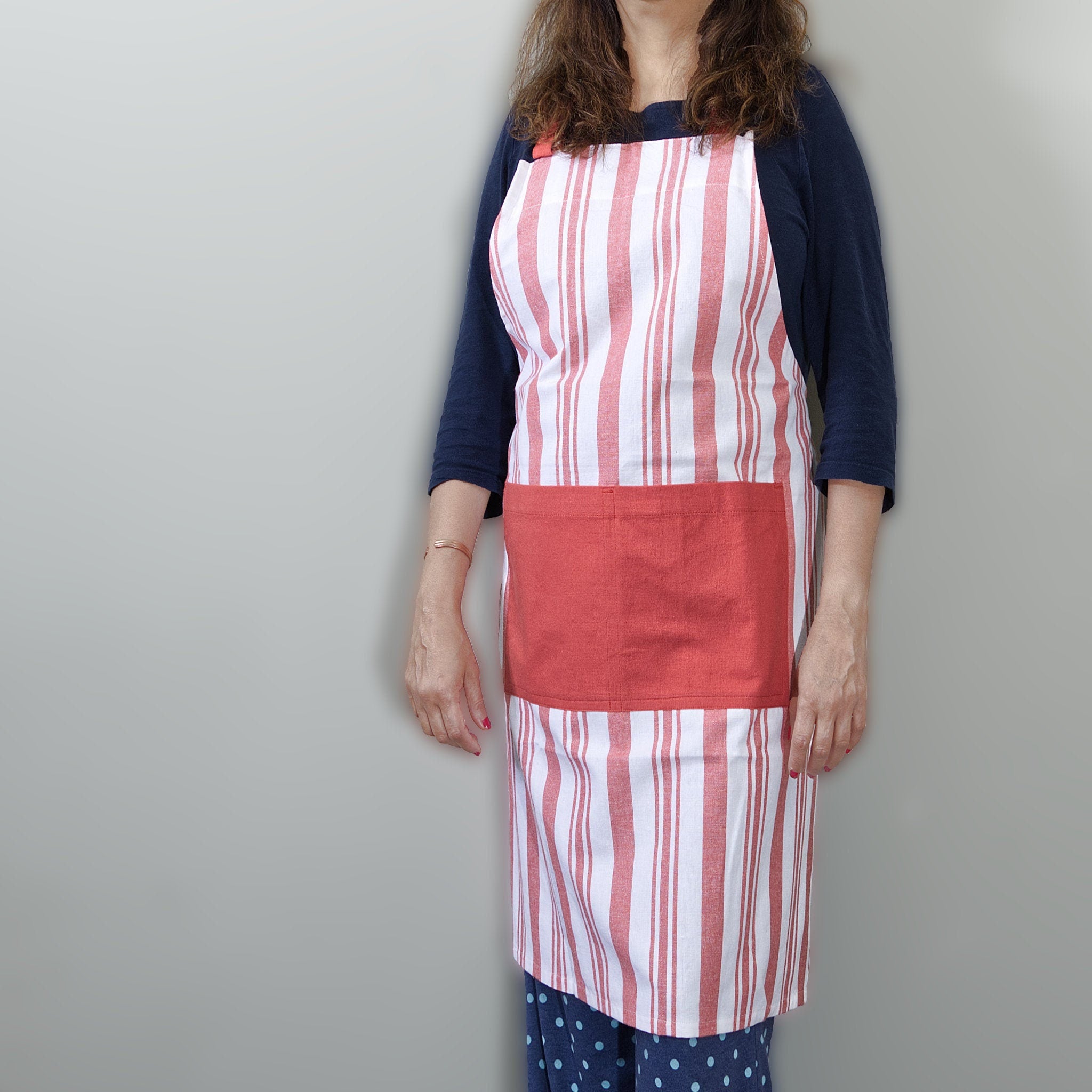 decade classic striped cotton Apon in red stripes on white, from Hem And Tassel on person  against a grey background