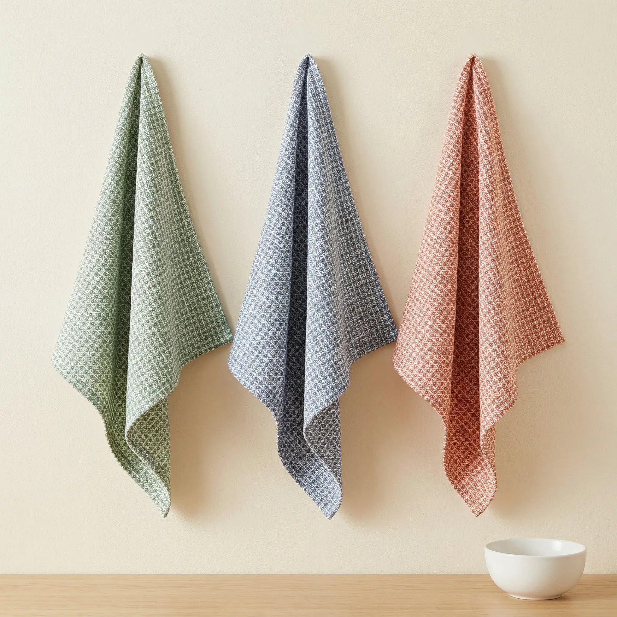 diamond waffle  - set of three 100% cotton kitchen towels in rust, blue and turf, hanging against a cream backdrop, from Hem And Tassel