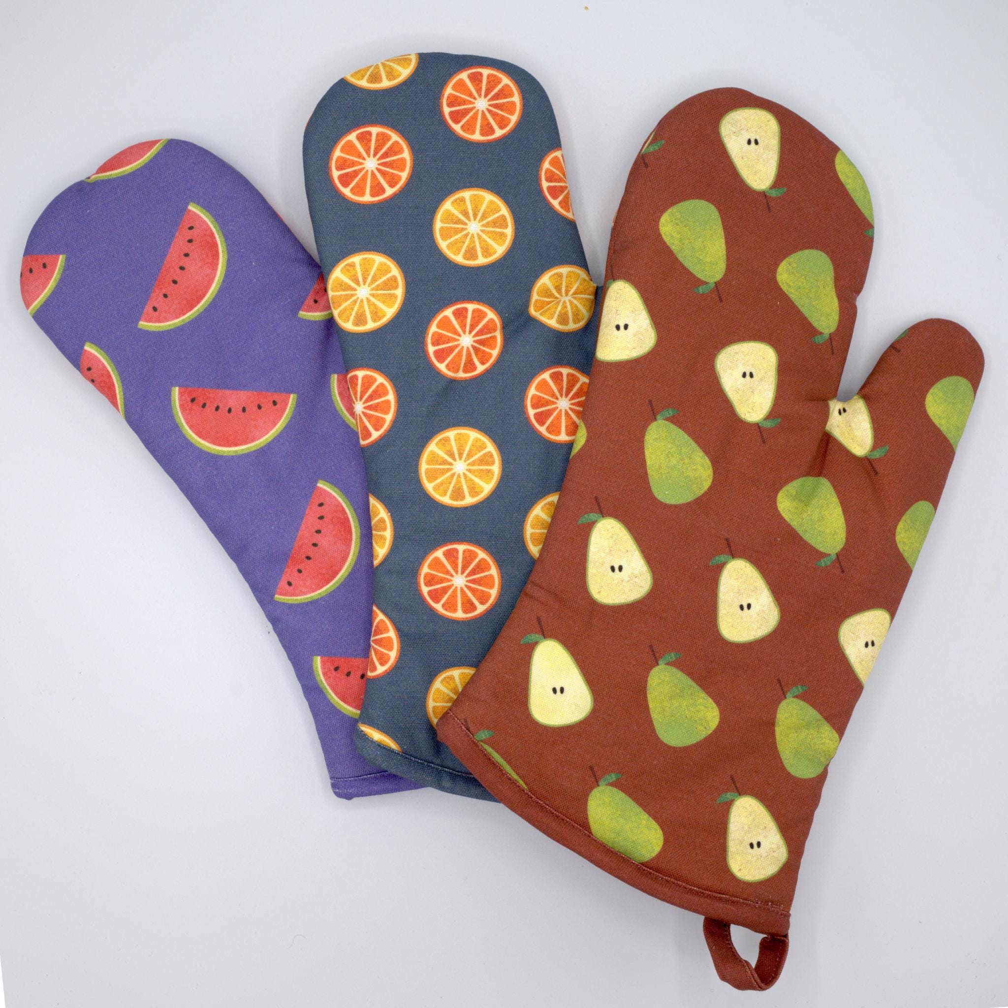Three oven mitts with faded fruit patterns from Hem And Tassel on a white background