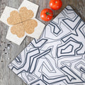 four heart clover cork coasters double up as trivet from Hem And Tassel with squiggles towel, tomatoes, salt and pepper on kitchen table