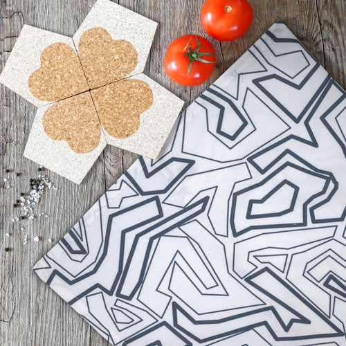 four heart clover cork coasters double up as trivet from Hem And Tassel with squiggles towel, tomatoes, salt and pepper on kitchen table