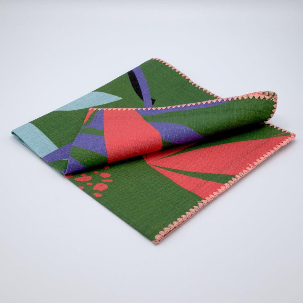 Folded green and pink 'pollen up' design dinner napkin of pure cotton by Hem And Tassel on a light gray background