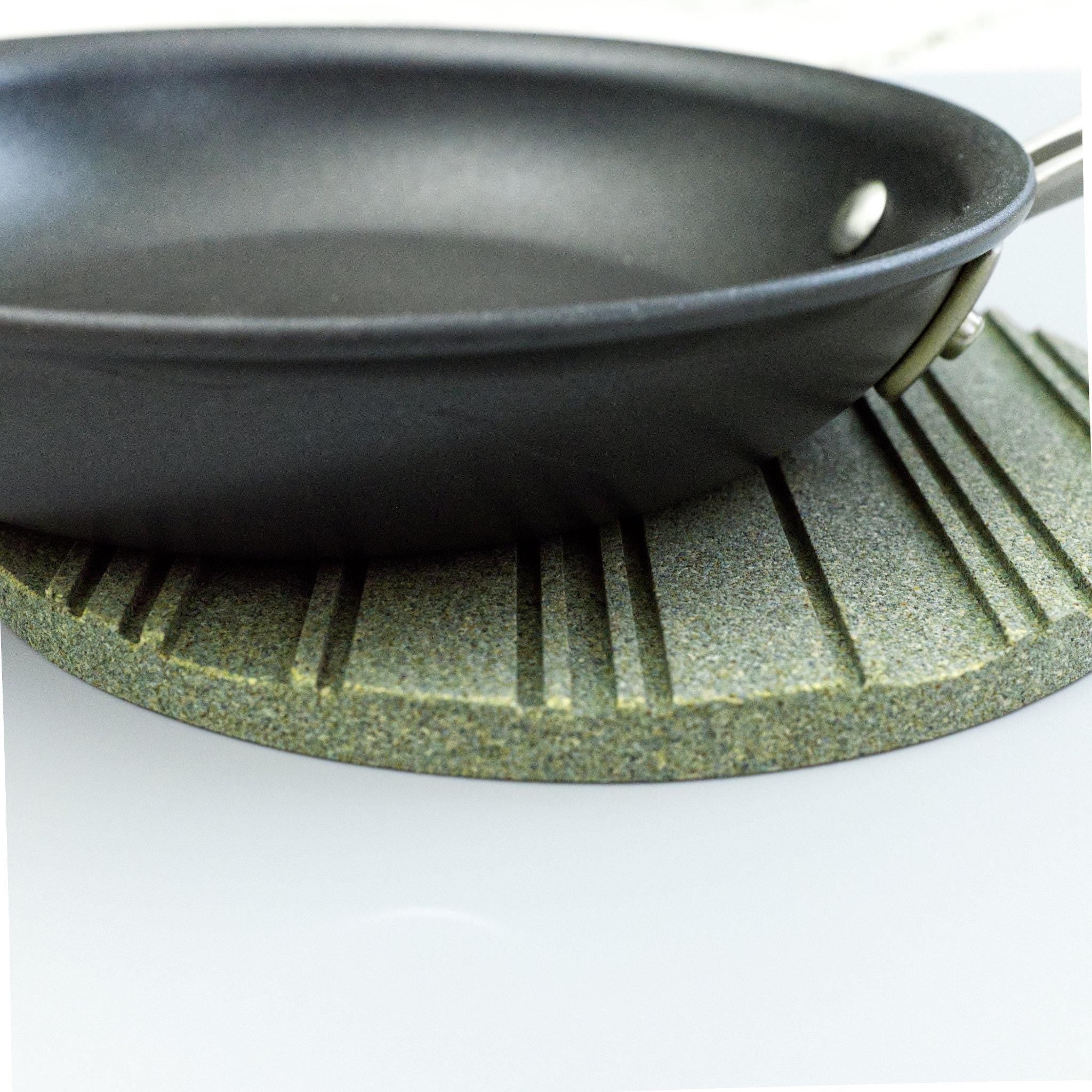 Black frying pan on a green heatsink cork trivet from Hem And Tassel 