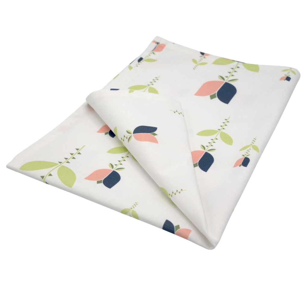 Hem And Tassel kitchen towel in white cotton with a stylized Art Deco tulip print in pink, green, and navy blue.
