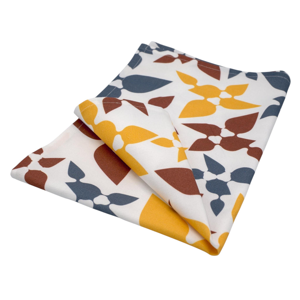 Hem And Tassel Celebration cotton kitchen towel with a white background and colorful leaf confetti pattern