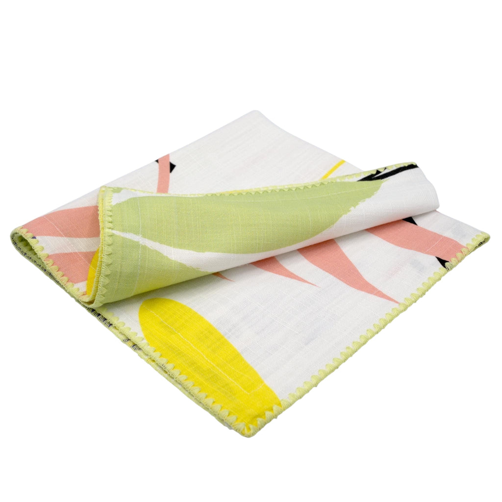 Hem And Tassel floral dinner napkin in textured slub cotton with pink, yellow, and green botanical print