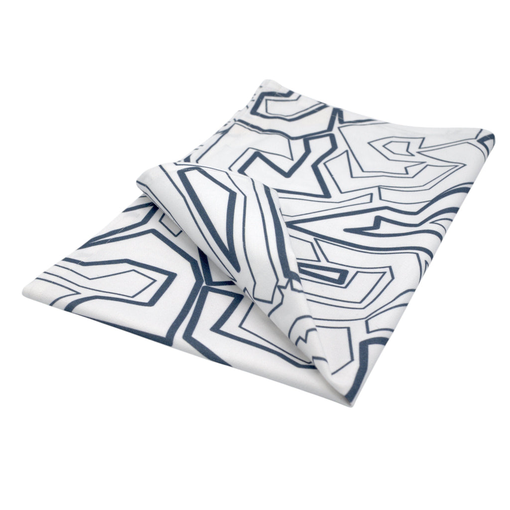 Hem And Tassel Squiggles cotton kitchen towel featuring a modern navy blue geometric line pattern on white fabric.