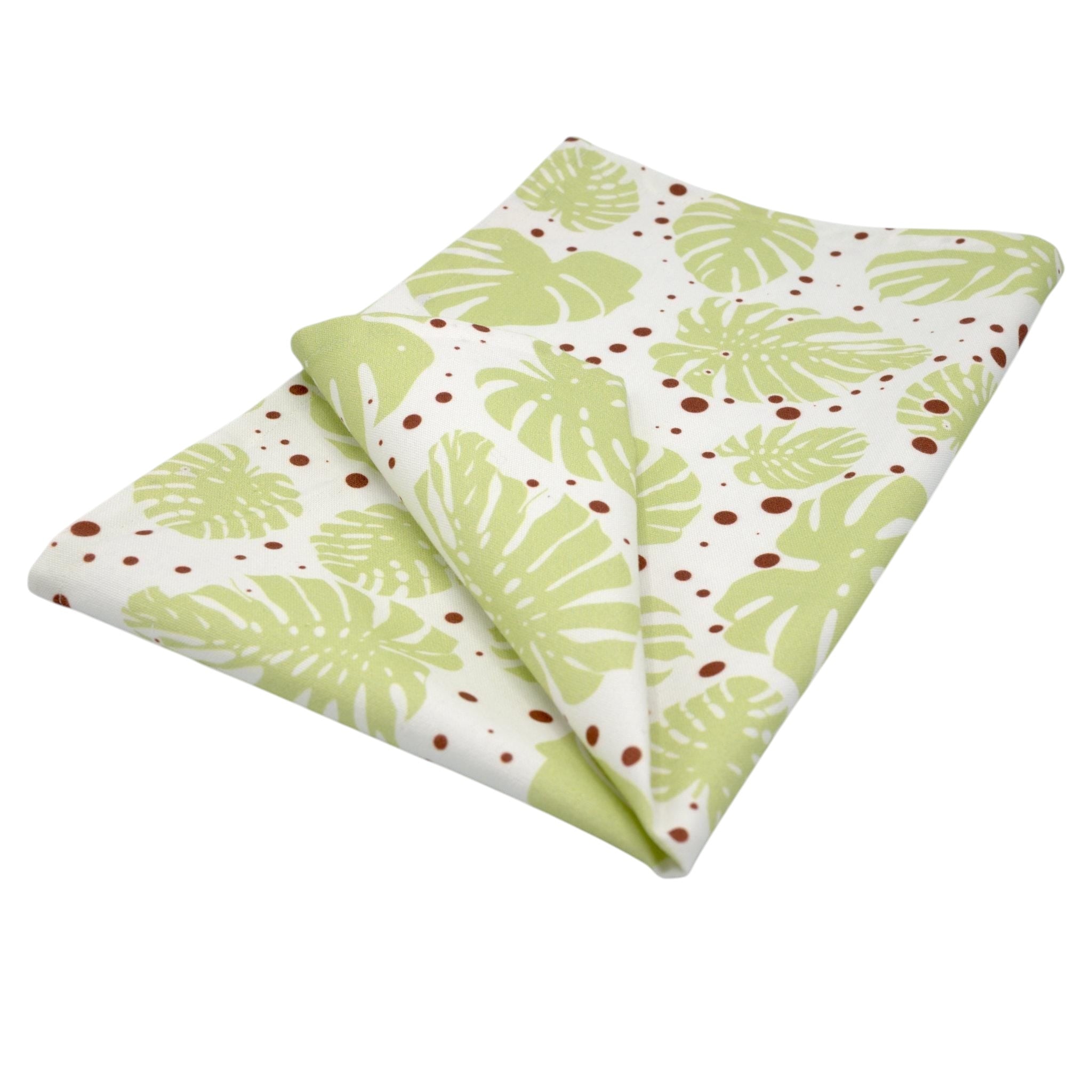 Hem And Tassel cotton kitchen towel featuring a light green monstera leaf print with brown polka dots