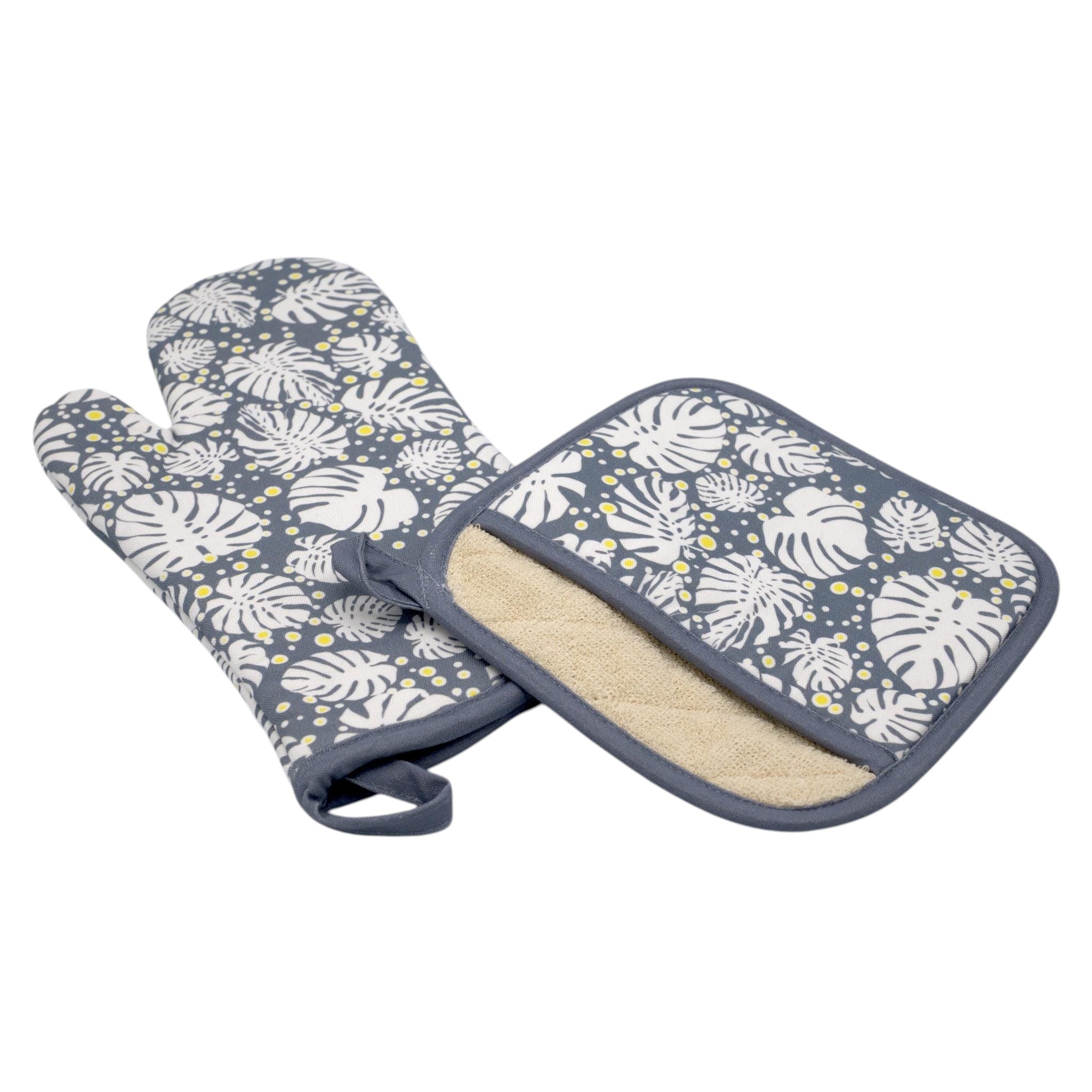 Hem And Tassel cotton oven mitt and pot holder set featuring a grey and white monstera leaf tropical print